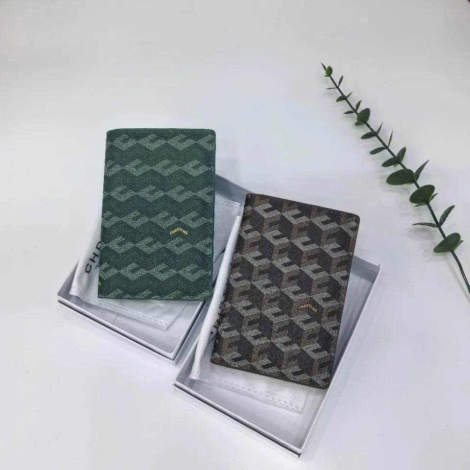 A dark green geometric print passport wallet is displayed in a silver-lined box next to a green leafy branch.