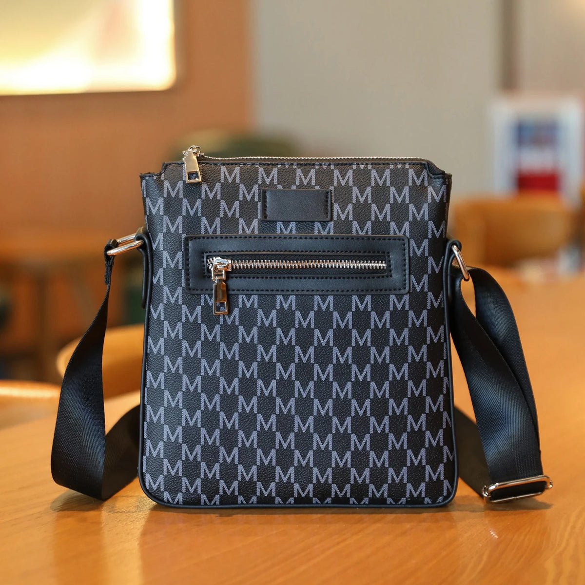 A dark gray patterned Men's Lightweight Crossbody Sling Bag resting on a wooden surface.