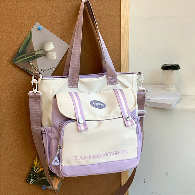 Helles lila und weißes Nylon-Korbhandtasche, die an einer Holzoberfläche hängt.