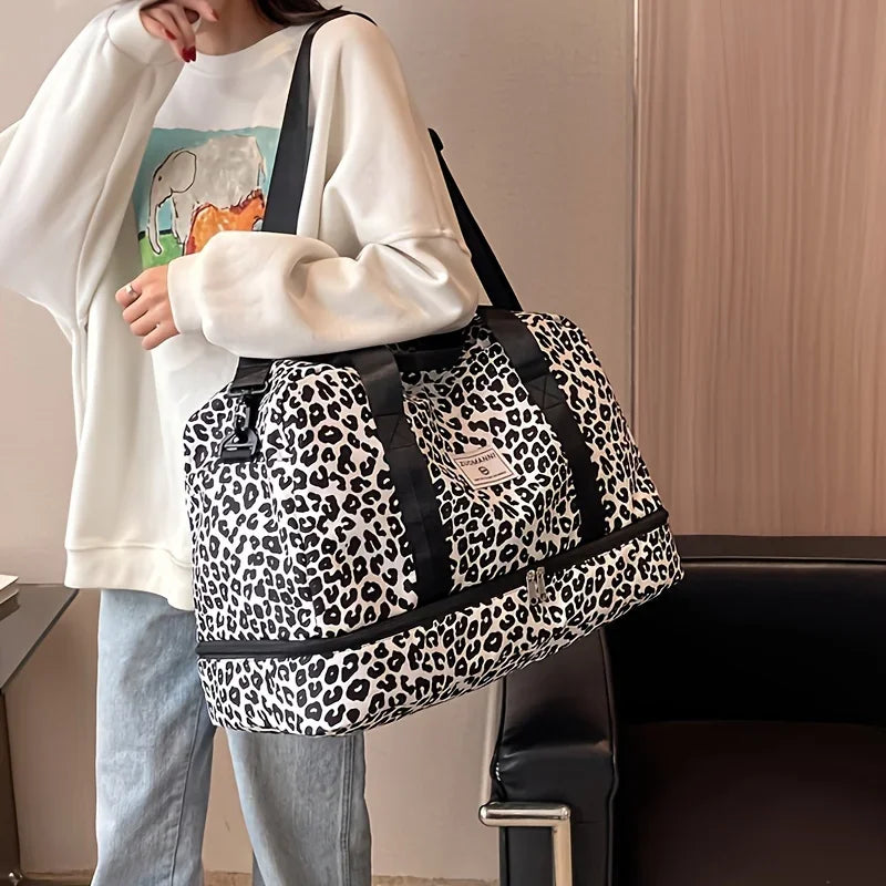 A person is carrying a black and white leopard print nylon travel duffle bag over their shoulder.