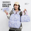 A woman is holding a purple star-patterned nylon backpack and a matching pouch against a white background.
