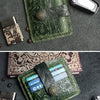 A green floral patterned genuine leather card wallet displayed on a dark gray surface with a black card visible.