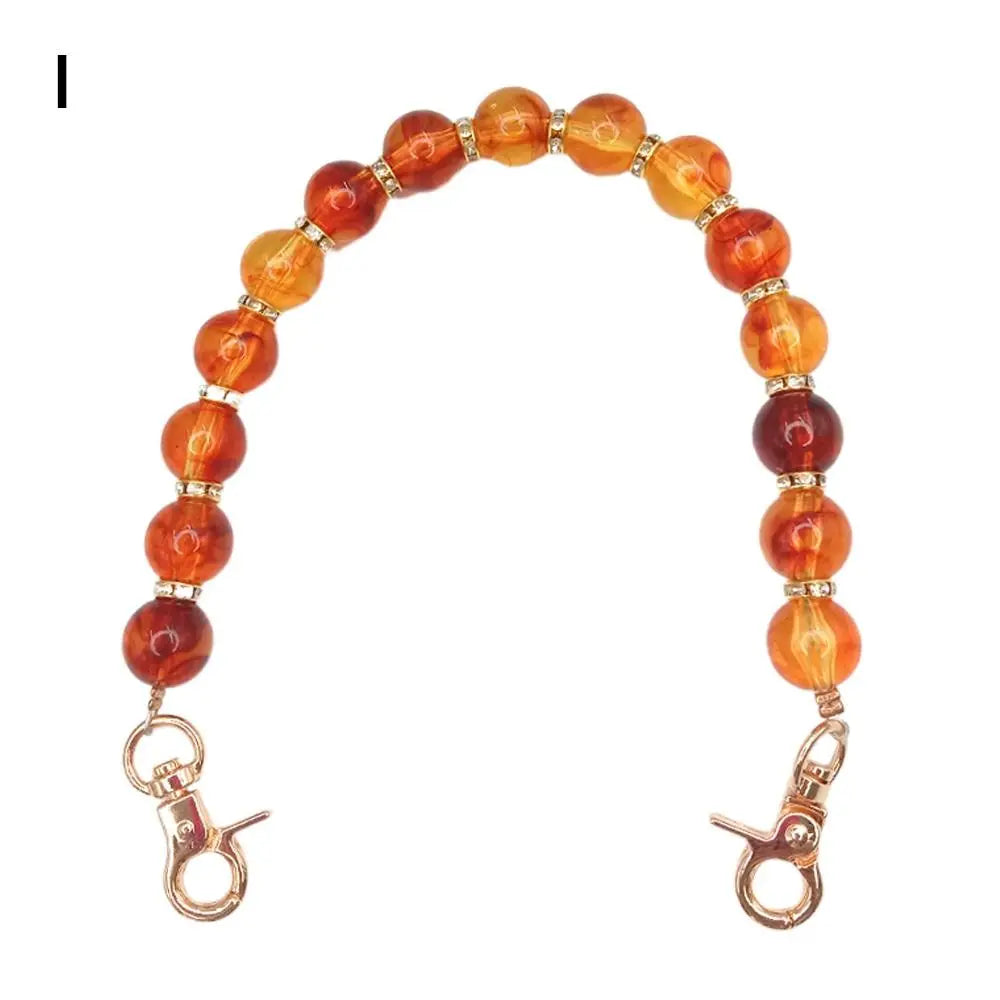 Handcrafted resin stone bead bag chain with round amber and orange beads.