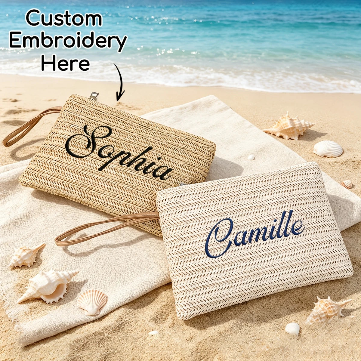 Two handwoven straw makeup bags, one labeled Sophia and the other Camille, are placed on sandy beach with seashells.