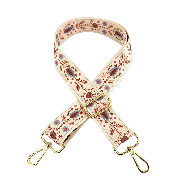 Sangle en cuir beige réglable avec motif floral et quincaillerie dorée.