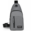A gray men's versatile crossbody sling chest bag with a black strap and a sports logo.