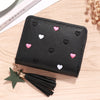 Black compact PU leather wallet with a zipper closure decorated with small pink and white heart embellishments and a black ta
