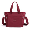A maroon durable nylon tote bag with dark red straps and a secure zipper closure.