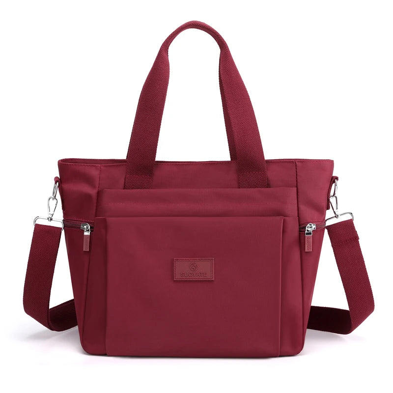 A maroon durable nylon tote bag with dark red straps and a secure zipper closure.