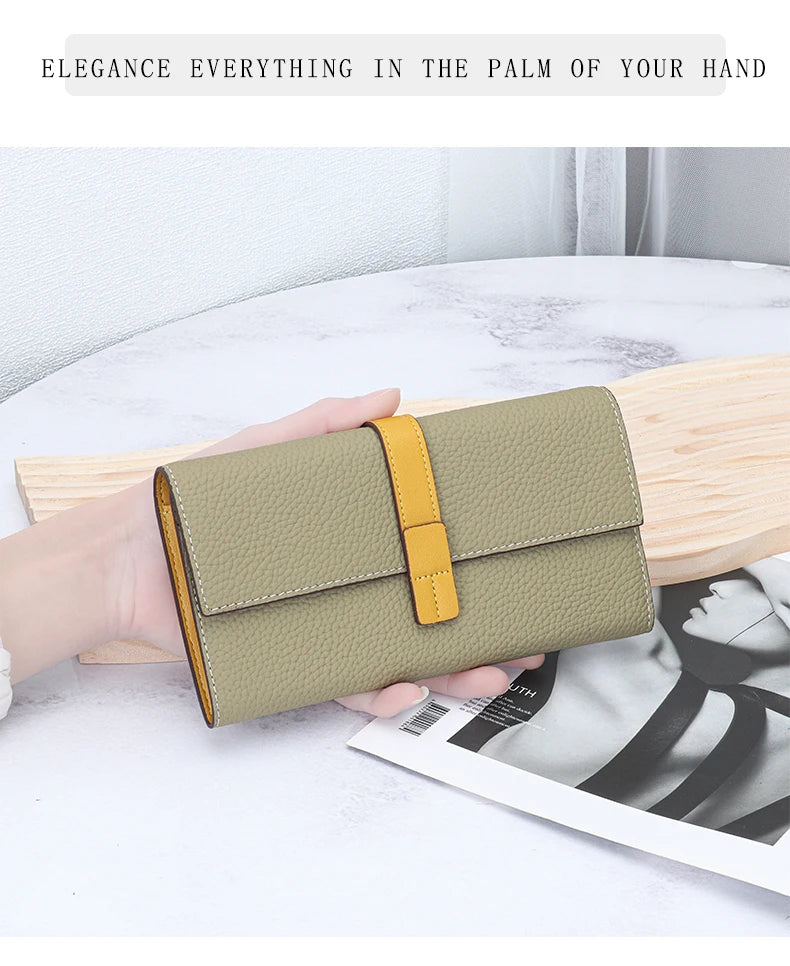 A beige genuine cow leather bifold wallet with a yellow accent is held in a hand on a white surface.
