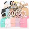 Assortment of silicone bead bracelets and leather card holders in various pastel and neutral colors