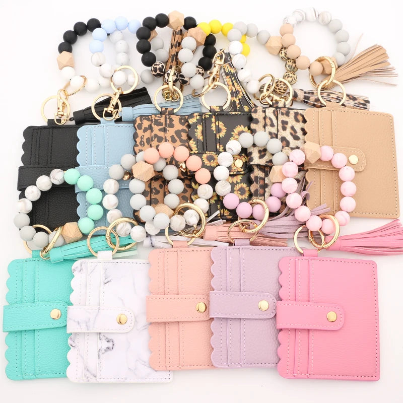 Assortment of silicone bead bracelets and leather card holders in various pastel and neutral colors