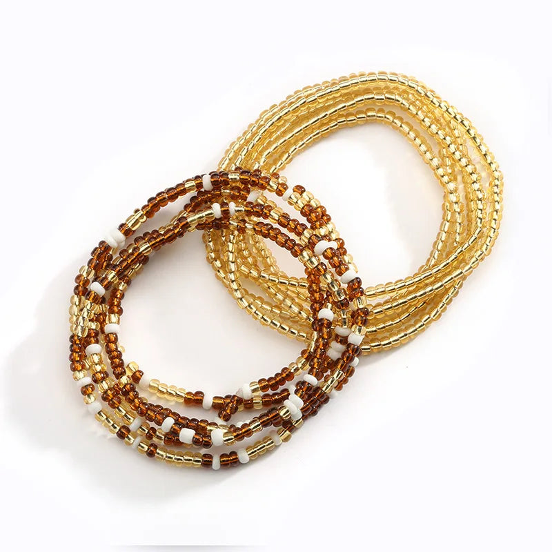 A close-up of colorful belly bead chains made of gold and amber beads.