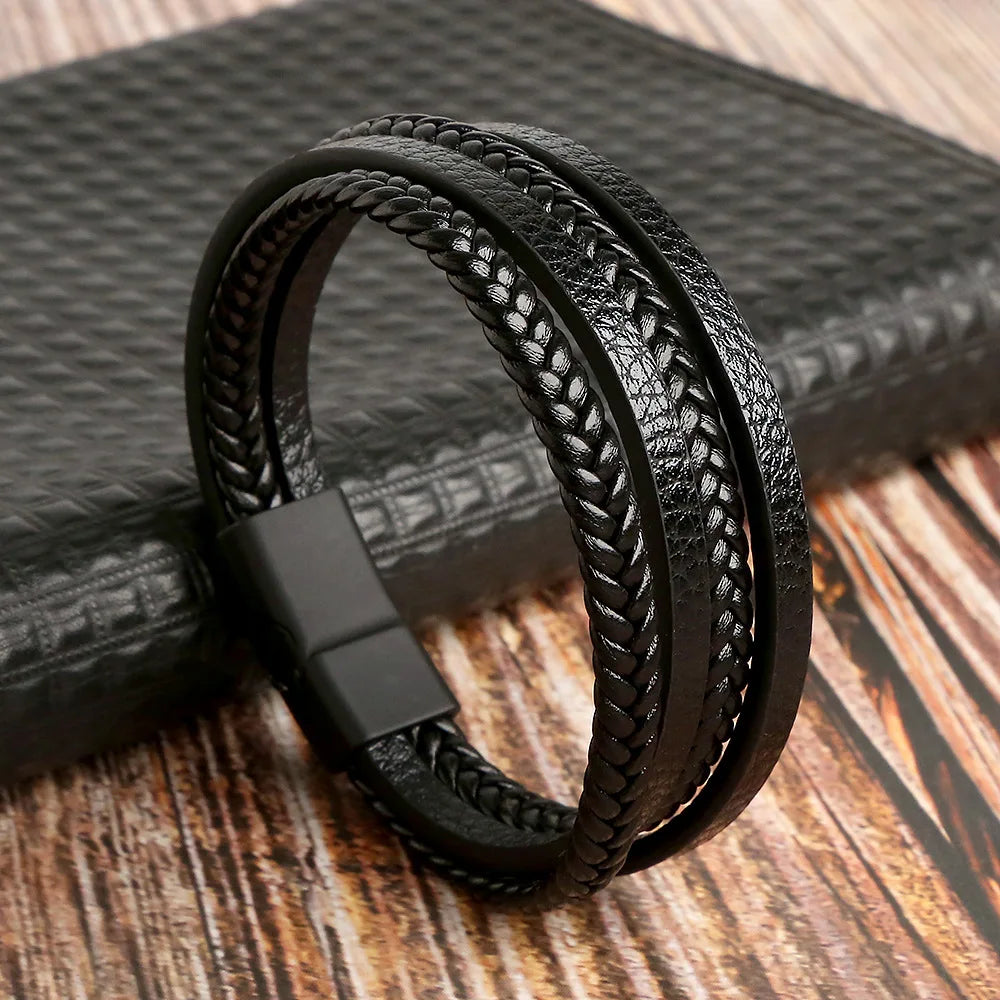 A black multi-layer leather bracelet with textured beads resting on a dark surface.