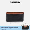 A black leather tote bag with a brown trim and a matching organizer insert.