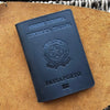 A dark blue leather passport holder embossed with the text UNIONE EUROPEA REPUBBLICA ITALIANA and PASSAPORTO placed on a brow