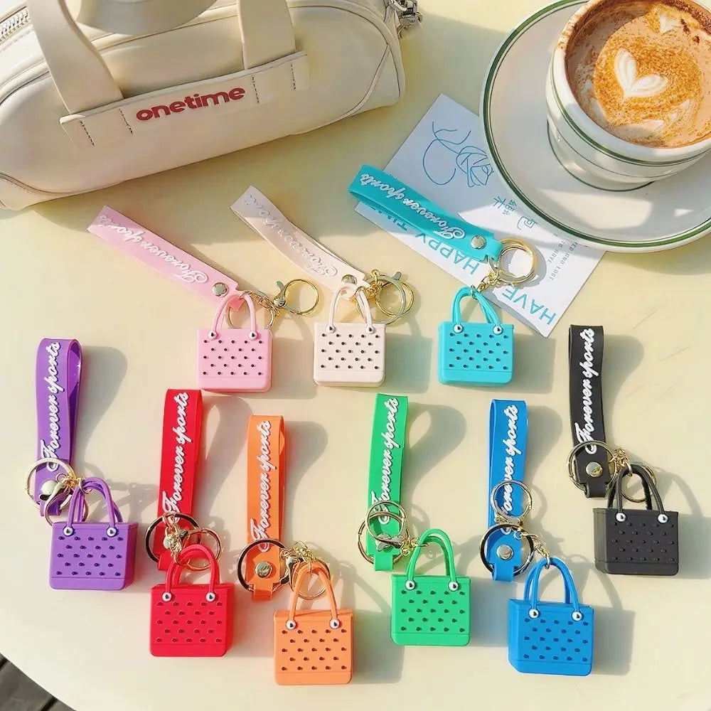 A collection of colorful silicone heart beach bag keychains displayed on a light surface.