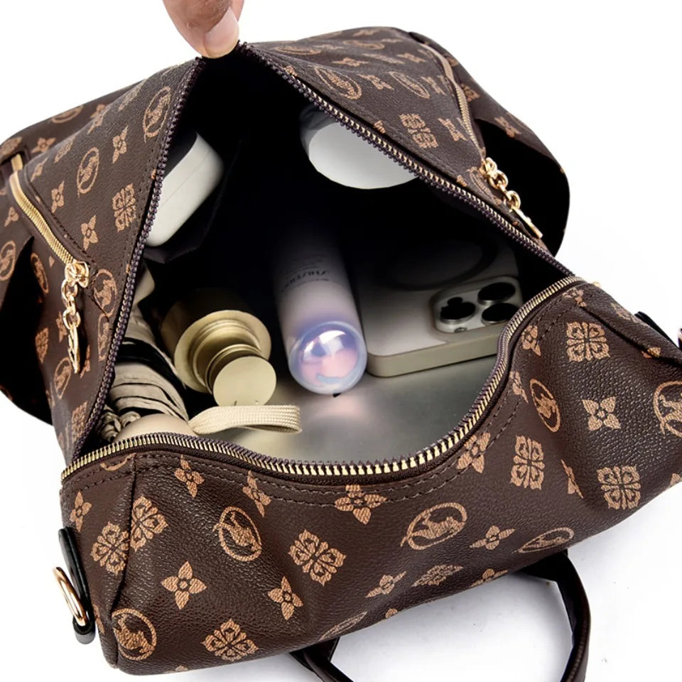 A brown genuine leather women's backpack is open, showing a padded interior with various small items.