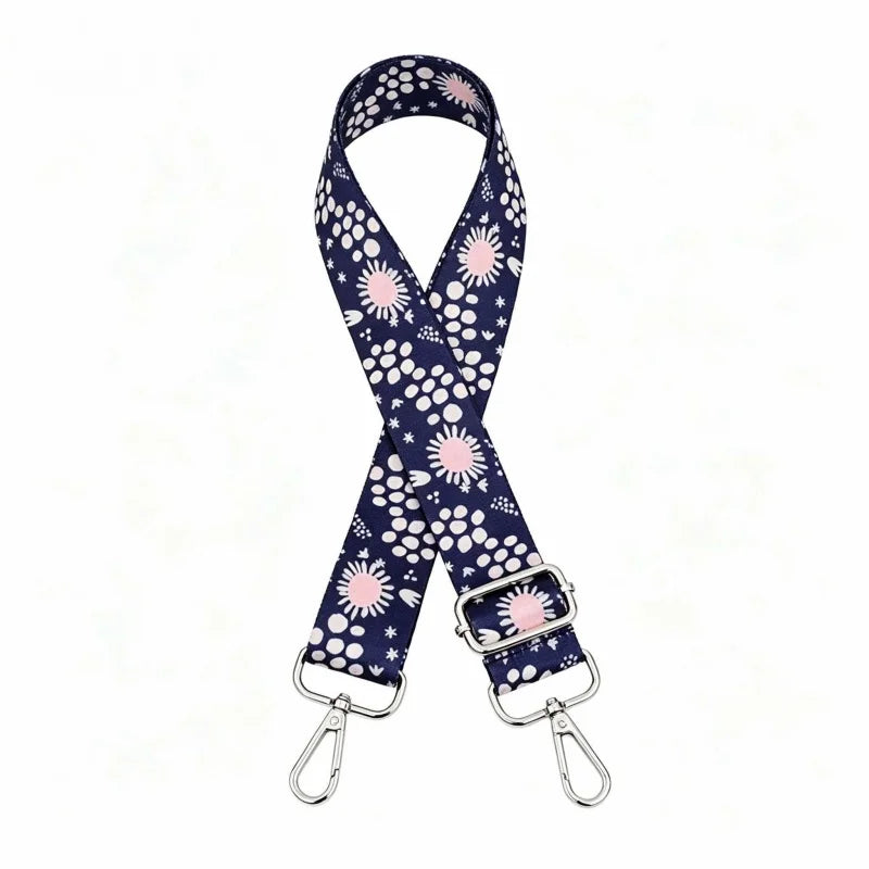 A navy blue and white polka dot nylon shoulder strap for bags and purses.