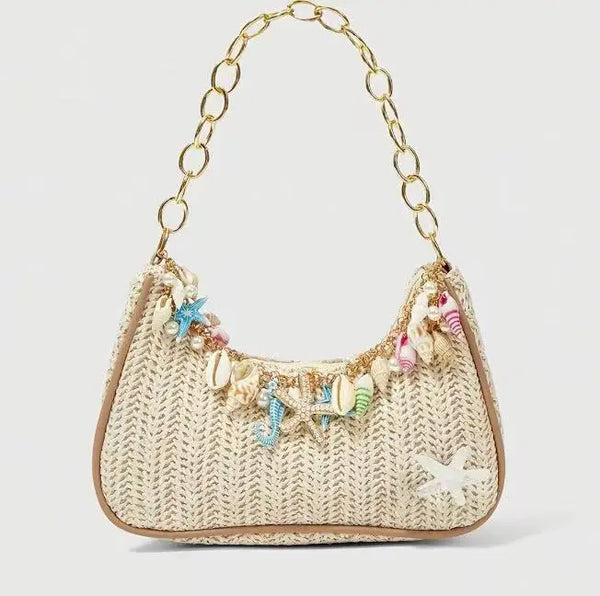 Sac à main en paille beige tissé décoré de charms thématiques marines colorés.