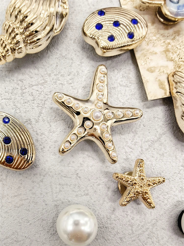 A collection of gold and silver ocean-themed shoe charms including a conch shell, starfish, and pearl.