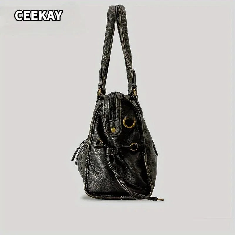A black vintage washed leather tote bag with a flap closure and gold hardware.