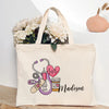 A beige canvas tote bag featuring a graphic design of a stethoscope, heart, and pills with the name Madison.
