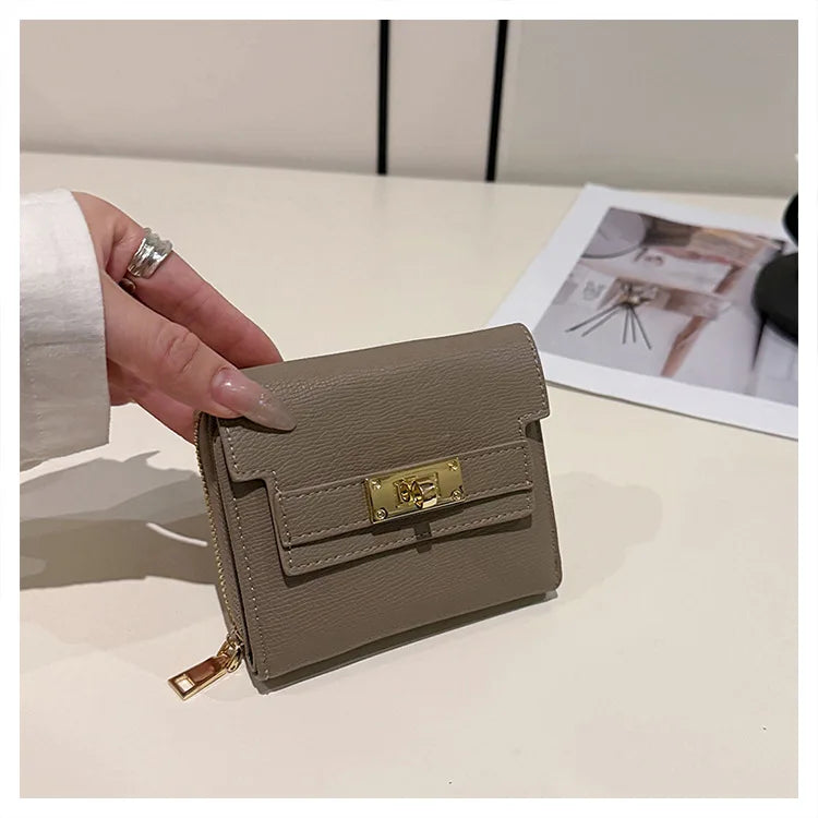 A beige multi-slot card holder is shown being held by a hand on a white surface.
