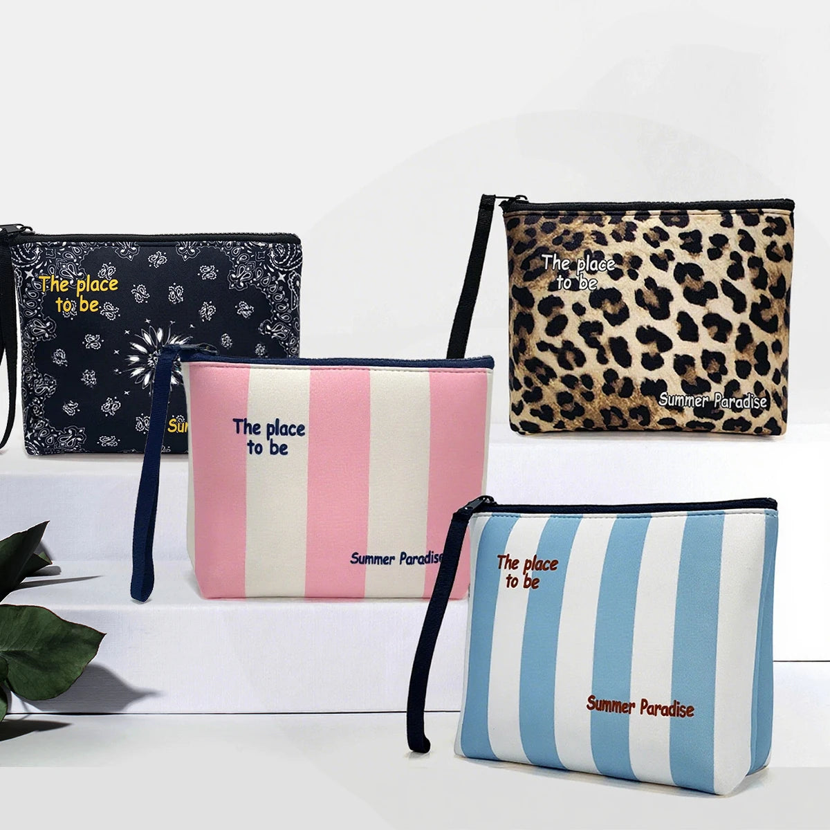 Una colección de cuatro bolsas cosméticas con diversos estampados, incluyendo leopardo, rosa y rayas azules.