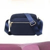 Navy blue compact oxford fabric crossbody bag with a gold zipper and dark blue strap