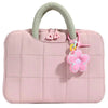 A pink quilted laptop sleeve with a light green handle and pink flower charm.