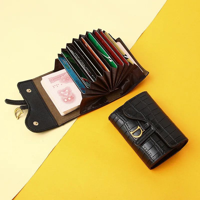 Portefeuille à carte en cuir noir, contenant des cartes de crédit et une carte imprimée rose.