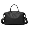 A black durable nylon travel duffle bag with leather handles and straps.