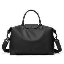 A black durable nylon travel duffle bag with leather handles and straps.