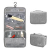 Sac organisateur portable en tissu gris avec plusieurs compartiments et une poignée.