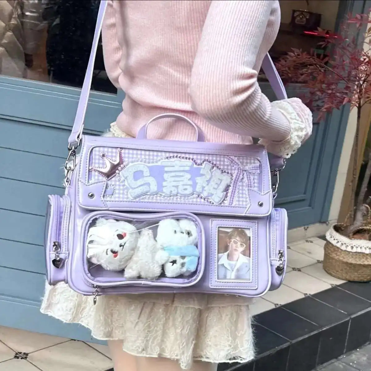 A pink sweater-clad person holds a purple Y2K transparent PU crossbody bag decorated with white fluffy animals and a photo.