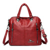 A maroon leather fashion crossbody backpack bag with silver hardware.