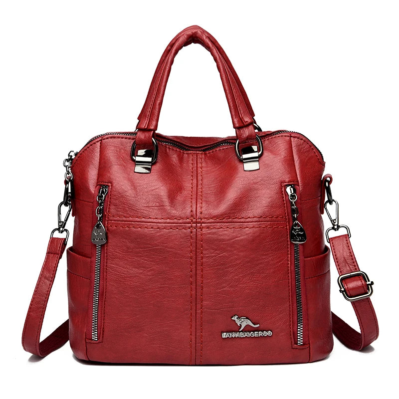 A maroon leather fashion crossbody backpack bag with silver hardware.