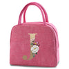 A pink insulated canvas lunch bag featuring a gold letter J and floral design.