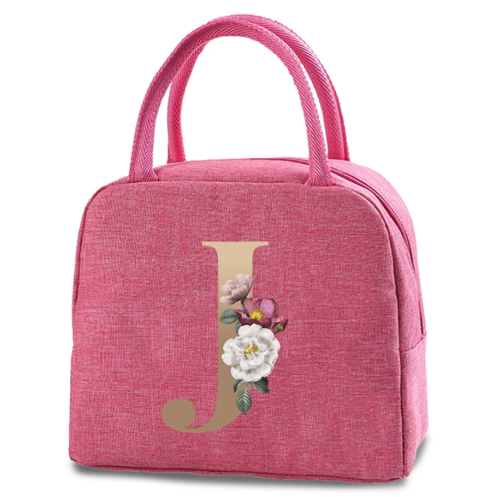 A pink insulated canvas lunch bag featuring a gold letter J and floral design.