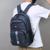 A navy blue lightweight commuter backpack worn by a person, featuring black accents and white stripes.