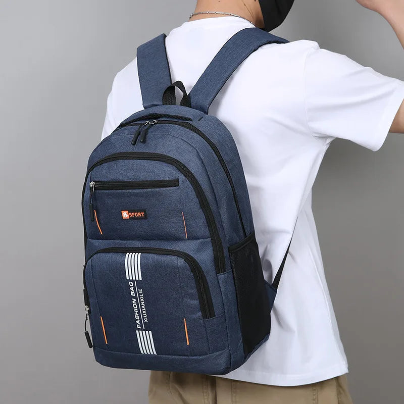 A navy blue lightweight commuter backpack worn by a person, featuring black accents and white stripes.