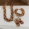 A set of gold-toned leopard print interlocking dangle jewelry, including a necklace and several earrings.