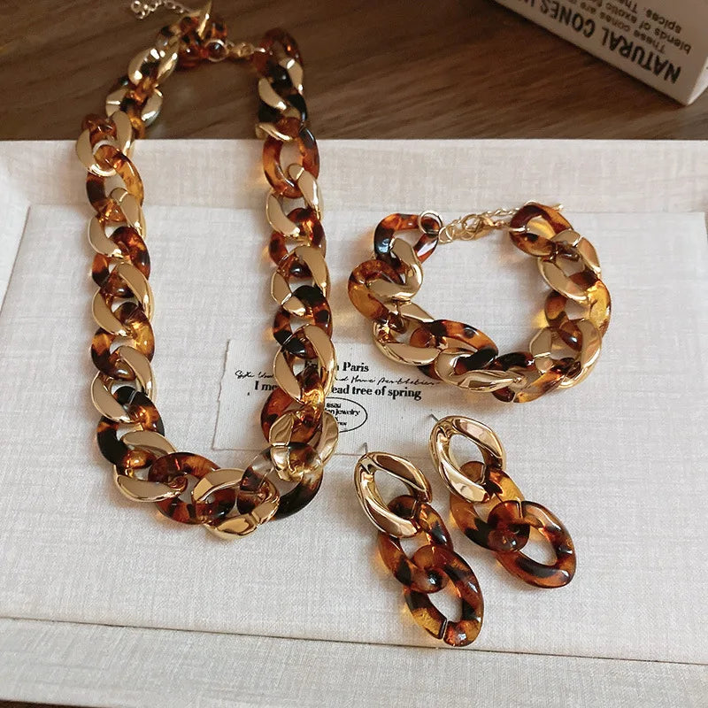 A set of gold-toned leopard print interlocking dangle jewelry, including a necklace and several earrings.