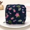 A dark blue pouch with a floral pattern featuring pink and green leaves, used for storing sanitary napkins.