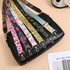 A black nylon crossbody bag featuring multiple colorful patterned straps with metal buckles.