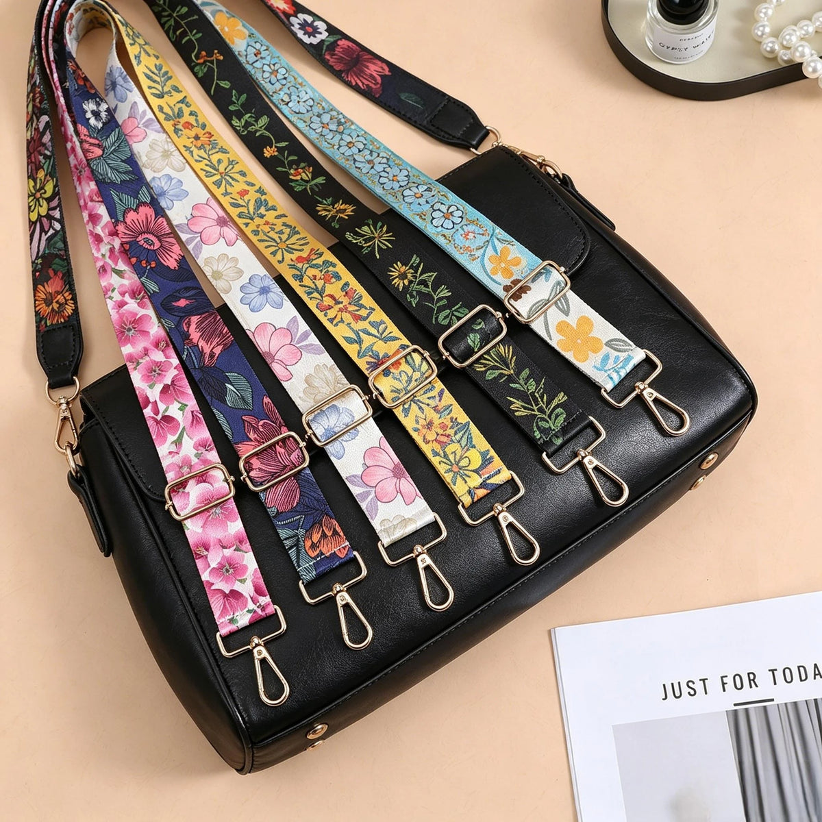 A black nylon crossbody bag featuring multiple colorful patterned straps with metal buckles.