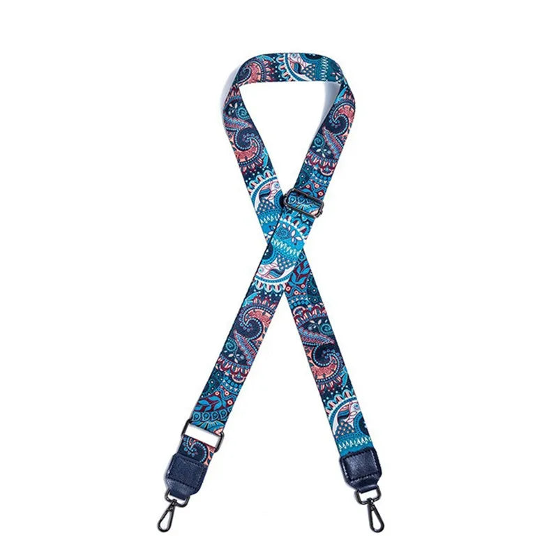 A blue and teal patterned textile replacement bag strap with a buckle and metal aglets.