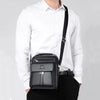 A black vintage PU leather crossbody messenger bag worn by a man in a white shirt.