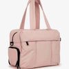 A light pink large capacity women's travel duffle bag with pink fabric and black trim.